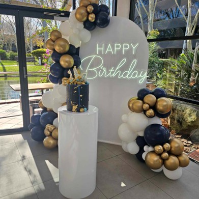 Wit neon bord Happy Birthday op een verjaardagsdecor met ballonnen
